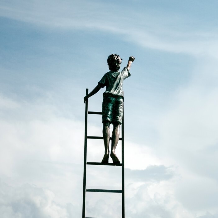 Mensch auf einer Leiter greift zum Himmel