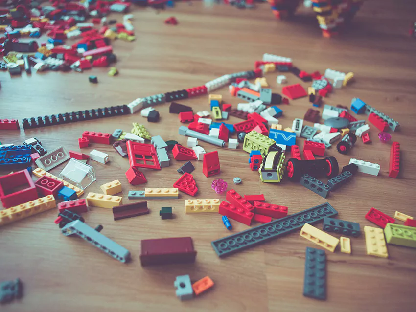 Verstreute Lego-Bausteine auf Holzfußboden
